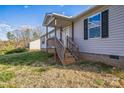 View of the home's front entrance, with a wooden porch and stairs leading to the front door at 340 W Memorial Hwy, Harmony, NC 28634