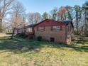 A cozy brick house featuring traditional architecture, a red roof, and a well-maintained lawn at 3442 Lester St, Conover, NC 28613