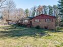 A brick house featuring traditional architecture, a red roof, and a well-maintained lawn at 3442 Lester St, Conover, NC 28613