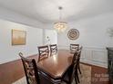 Formal dining room boasting a dark wood table, chandelier, and classic wainscoting details at 4127 Stacy Blvd, Charlotte, NC 28209