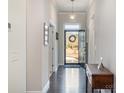 Elegant hallway with hardwood floors, neutral walls, and a view of the front door at 456 Lucky Dr, Concord, NC 28027