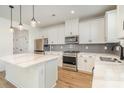 Modern kitchen with stainless steel appliances, a center island, white cabinetry, and gray subway tile backsplash at 5013 Dunsford Dr, Denver, NC 28037