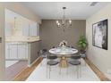 Elegant dining area featuring a modern chandelier, stylish chairs, and a round table set for a delightful meal at 6635 Vlosi Dr, Charlotte, NC 28226