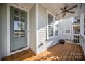 Inviting front porch features a wooden deck, fan, and pleasant view from the front door and window at 758 Waterscape Ct, Rock Hill, SC 29730