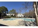 Community pool surrounded by mature trees and landscaping, offering a refreshing retreat at 9130 Charminster Ct, Charlotte, NC 28269