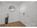 Bright entryway featuring wood-look flooring, a stylish mirror, and a modern front door at 9418 Stately Oak Ln, Mint Hill, NC 28227