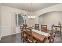 Traditional dining room featuring a wooden table, chandelier, wainscoting, and a large window at 1004 Whipcord Dr, Waxhaw, NC 28173