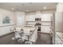 Bright eat-in kitchen featuring stainless steel appliances, granite countertops, and a center island with seating at 1004 Whipcord Dr, Waxhaw, NC 28173