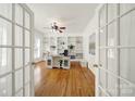 Bright home office with custom built-in bookshelves, hardwood floors, and French doors for a private workspace at 1569 Benjamen Latrobe Cir, Fort Mill, SC 29708