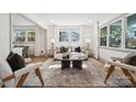 Well-lit living room with a comfortable seating arrangement, large windows, and a clear view into the dining area at 1749 Archdale Dr, Charlotte, NC 28210