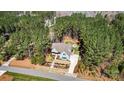 Stunning aerial view of blue home nestled among lush green trees with a firepit in the backyard at 188 Winding Forest Dr, Troutman, NC 28166