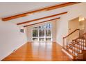 Bright living room with hardwood floors, exposed beams, and lots of light coming in from large windows at 2300 Highlawn Dr, Charlotte, NC 28212