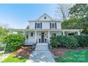 Beautiful two-story home showcasing a covered front porch, classic white exterior, and well-manicured landscaping at 234 N Race St, Statesville, NC 28677