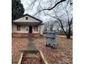 Exterior view of the home's neglected facade and overgrown yard at 2501 Booker Ave, Charlotte, NC 28216