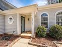 Inviting front porch and door with stylish columns and landscaping around the home's exterior at 2518 Eargle Rd, Charlotte, NC 28269