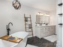 Modern bathroom with a freestanding tub, dual vanity, and a stylish ladder for towels at 6087 Diamond Pl, Harrisburg, NC 28075