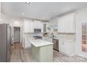 Bright kitchen with white cabinets, stainless steel appliances, and a light green kitchen island at 6087 Diamond Pl, Harrisburg, NC 28075