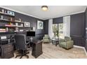 Home office with a dark wood desk, comfortable seating, and natural light from the window at 6087 Diamond Pl, Harrisburg, NC 28075