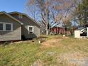 View of home's backyard with shed and detached garage surrounded by lush green grass at 701 Betty St, Gastonia, NC 28054