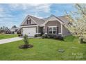 Beautiful home with lush green lawn, complemented by brick accents, and a two car attached garage at 815 Foxmeade Ct, Salisbury, NC 28144