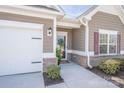 Up-close view of the charming home entrance, with a welcoming wreath, brick accents and a two-car garage at 815 Foxmeade Ct, Salisbury, NC 28144