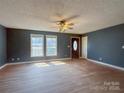 Spacious living room with hardwood floors, ceiling fan, and natural light from the front windows at 82 22Nd Nw Ave, Hickory, NC 28601