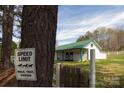 White horse barn with green trim and a speed limit sign at 11215 Idlewild Rd, Matthews, NC 28105