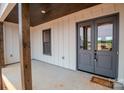 Inviting covered porch with wood columns and gray double front doors at 1370 Coppergate Dr, Salisbury, NC 28147