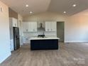 Open concept kitchen with a dark island, white cabinets and stainless steel appliances at 1370 Coppergate Dr, Salisbury, NC 28147
