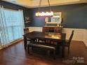 Inviting dining room featuring a dark wood table, modern chandelier, and wainscoting detail at 14117 Hiawatha Ct, Huntersville, NC 28078