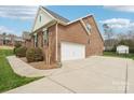 Back exterior view of brick home with attached two car garage and concrete driveway at 205 Cowboys Cir, Rock Hill, SC 29732