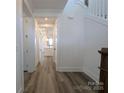 Bright hallway with sleek wood floors leading to a modern kitchen and staircase at 255 Luray Way # 442, Rock Hill, SC 29730