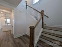 Elegant staircase with wooden banister and white risers, complemented by wood floors at 255 Luray Way # 442, Rock Hill, SC 29730