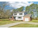 Charming two-story home boasts brick and vinyl siding, and a well-manicured lawn at 2611 Rolling Hills Dr, Monroe, NC 28110