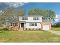 Charming two-story home boasts brick and vinyl siding, and a well-manicured lawn at 2611 Rolling Hills Dr, Monroe, NC 28110