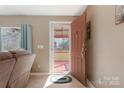 A view of the front door and red porch through the doorway of a neutrally painted living room at 3080 Sims Rd, Rock Hill, SC 29730