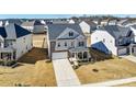 An aerial view showcases this lovely home with gray siding, complemented by brick accents, a two-car garage, and inviting porch at 4208 Stream Dale Nw Cir, Concord, NC 28027