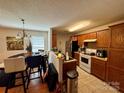 Functional kitchen with tiled floors, white appliances, and adjacent dining area at 5009 Oak Pasture Ln, Charlotte, NC 28269