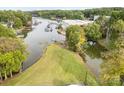 Aerial view showcasing the waterfront property with mature trees, well-maintained lawn, and boat dock access at 7790 Blackwood Rd, Denver, NC 28037