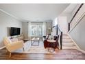 Cozy living room featuring hardwood floors, staircase, and plenty of natural light at 8250 Tradd Ct, Charlotte, NC 28210