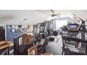 Spacious exercise room featuring a ceiling fan and an array of fitness equipment, needs decluttering at 9575 Old Concord Rd, China Grove, NC 28023