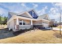 A charming home with a cozy front porch framed by white railings and stone accents at 9650 Liberty Hill Dr, Mint Hill, NC 28227