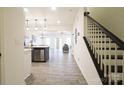 Open-concept entryway featuring wood-style flooring, stairs, and natural light at 13024 Suncreek Ter, Charlotte, NC 28214