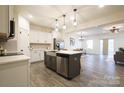 Modern kitchen with stainless steel appliances, white cabinets, and island with barstool seating at 13024 Suncreek Ter, Charlotte, NC 28214