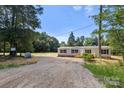 Home with gravel driveway surrounded by mature trees and nature on a spacious lot at 143 Lakewind Dr, Mooresville, NC 28115