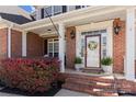 Charming front porch with brick columns, decorative plants, and a welcoming entrance with a floral wreath at 1736 Townsend Ln, Rock Hill, SC 29730