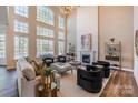 Bright living room features soaring windows, fireplace, neutral tones, and elegant furnishings at 6066 Jepson Ct, Charlotte, NC 28214