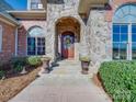 Charming stone entryway featuring a wood door, decorative wreath, potted plants, and stone steps at 810 Lake Wright Rd, China Grove, NC 28023