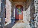 Close-up of front door with stone surround, wreath, 'hello' mat and decorative lanterns at 810 Lake Wright Rd, China Grove, NC 28023