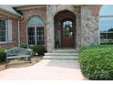 Charming front entrance with stone archway, brick accents, and decorative wreath at 810 Lake Wright Rd, China Grove, NC 28023